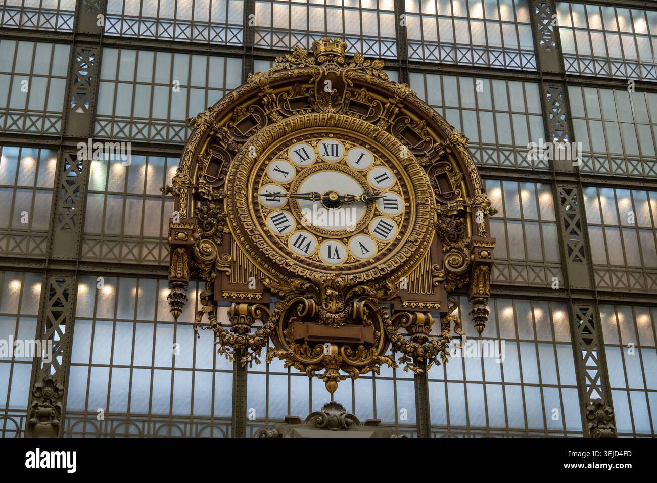 Parigi, Francia - 8 novembre 24: Primo piano dell'orologio dorato con numeri romani posti contro la grande vetrata all'interno del Musée d'Orsa Foto Stock