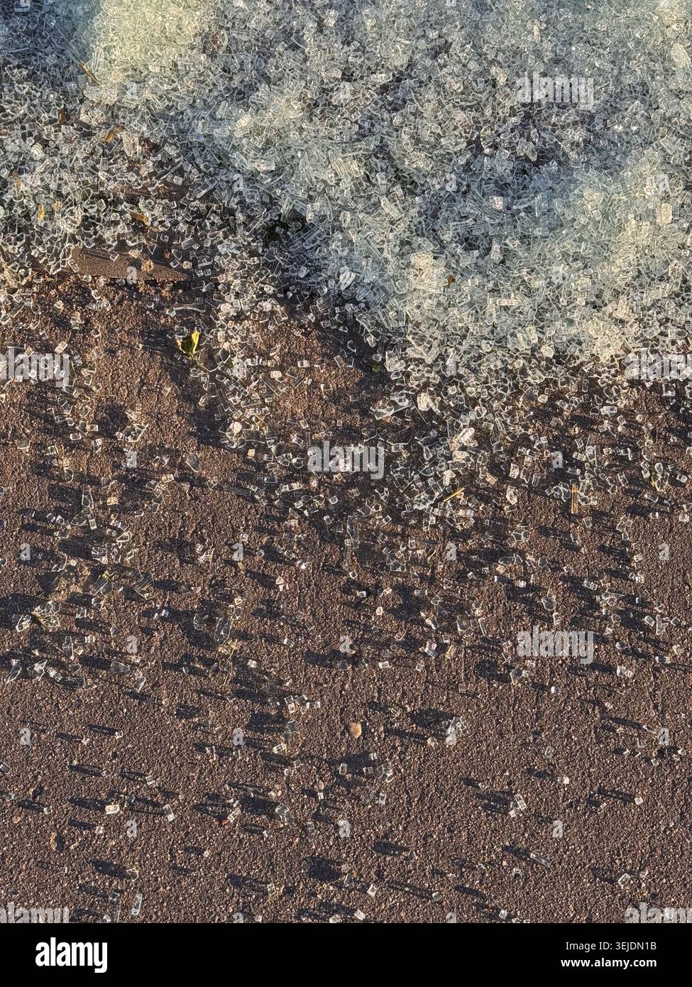 Pezzi di vetro temprato frantumato su asfalto Foto Stock