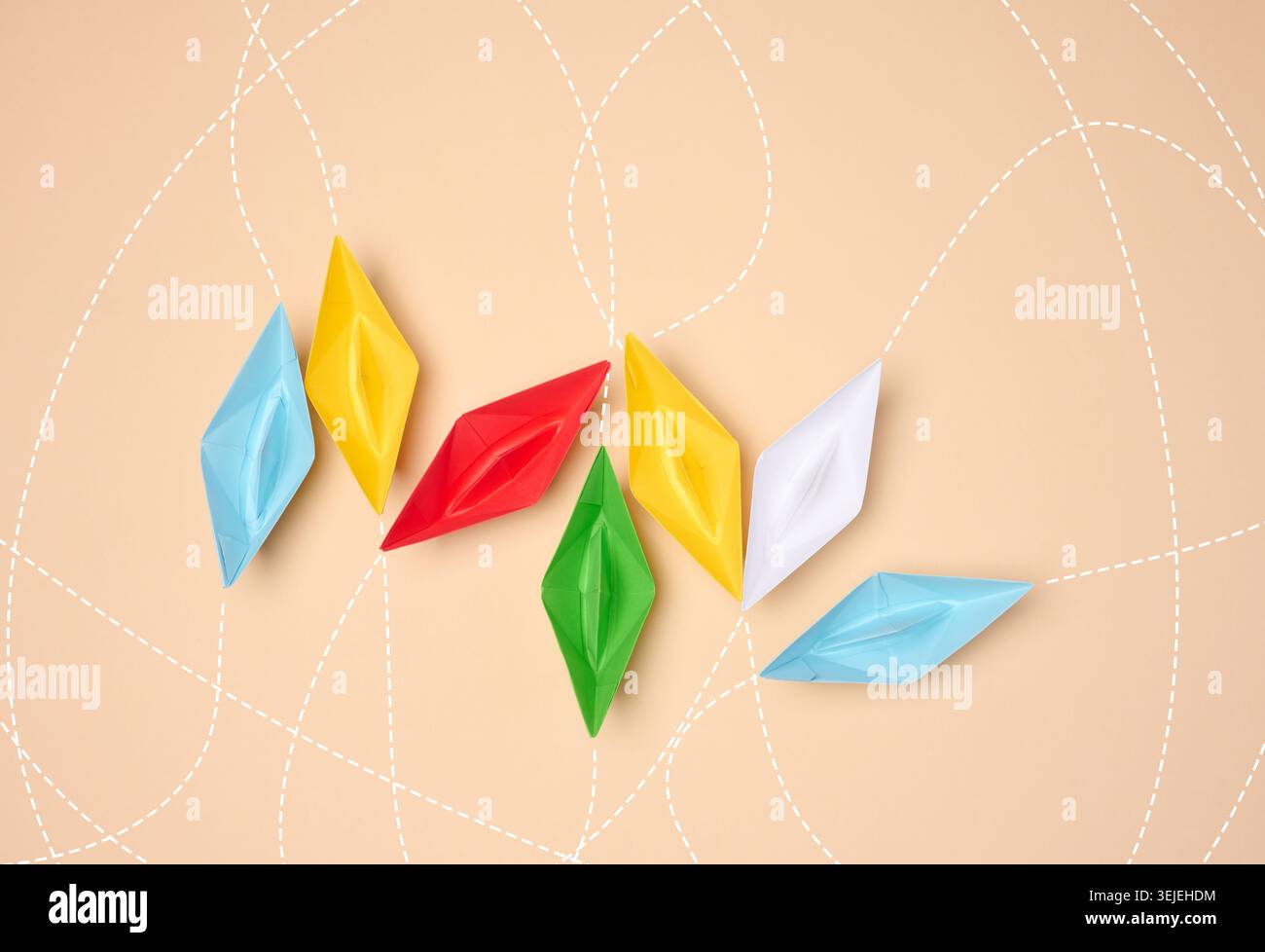 Barche di carta origami multicolore con linee tratteggiate che simboleggiano i percorsi su uno sfondo neutro. Foto Stock