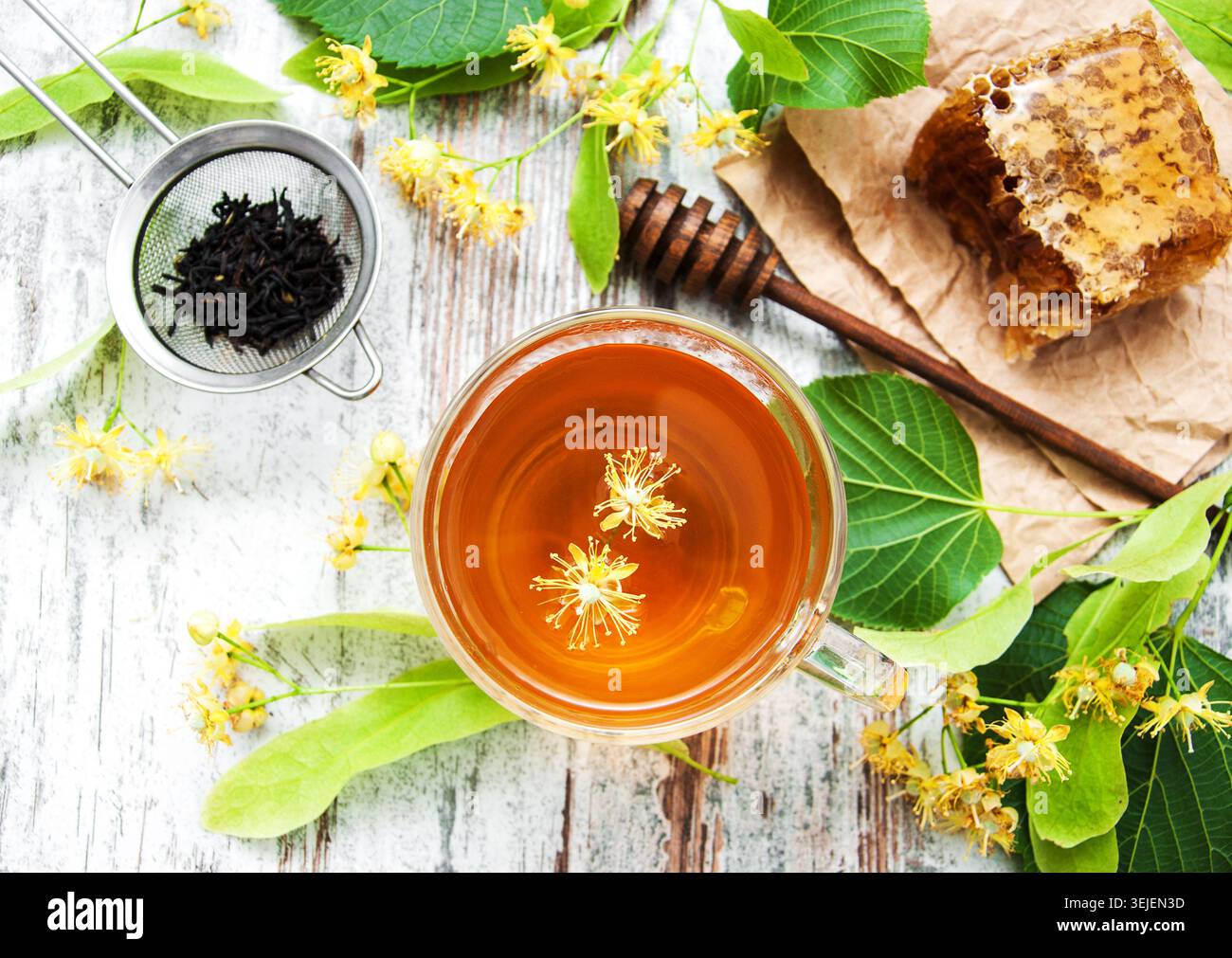 Pettine di miele, tè e fiori di tiglio su una tavola Foto Stock