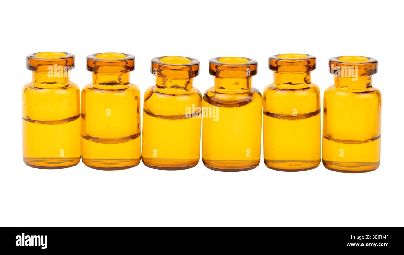 Fila di sei bottiglie mediche gialle con liquido trasparente Foto Stock