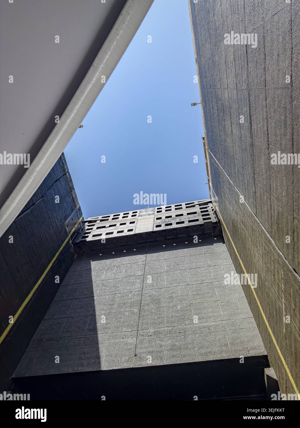 Guardando in alto dall'interno delle alte pareti di cemento di una chiusa per la navigazione sul fiume Douro Foto Stock