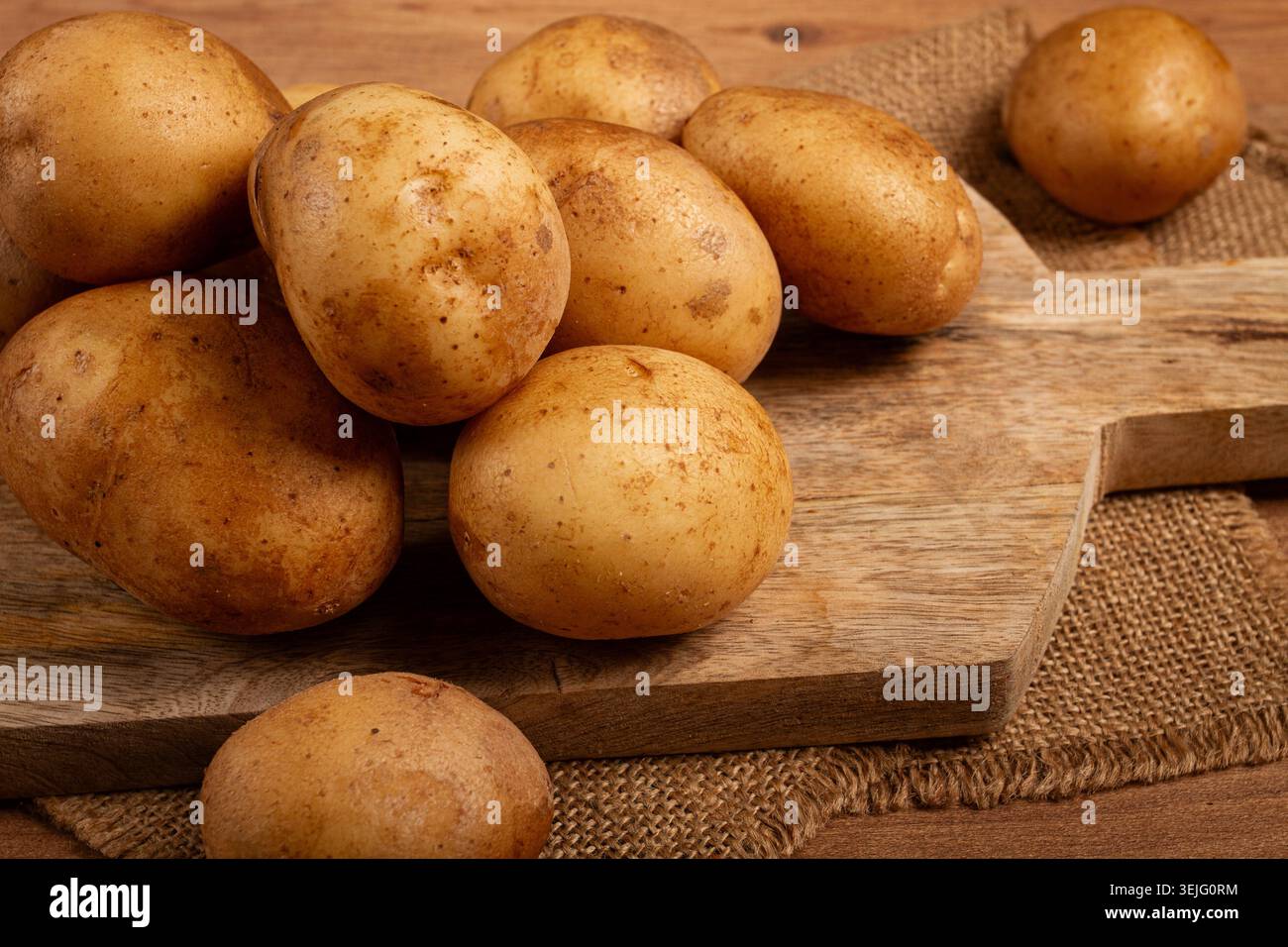 Patate crude, sparse su un tagliere, primo piano, nessuna persona, Foto Stock