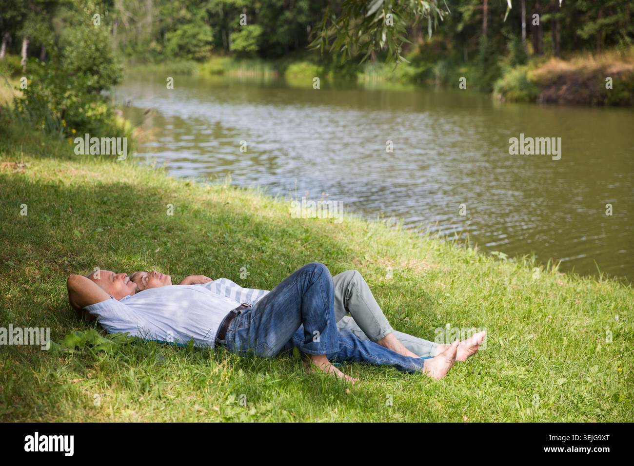 Felice coppia anziana stesa sull'erba Foto Stock