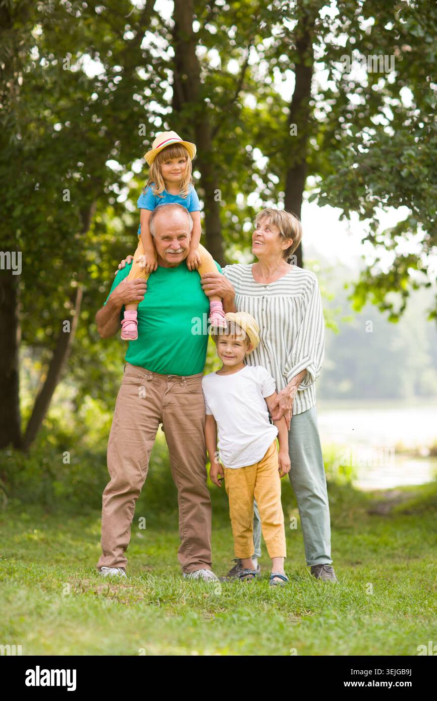 Nonni e nipoti in estate all'aperto. Concetto di famiglia amichevole. Foto Stock