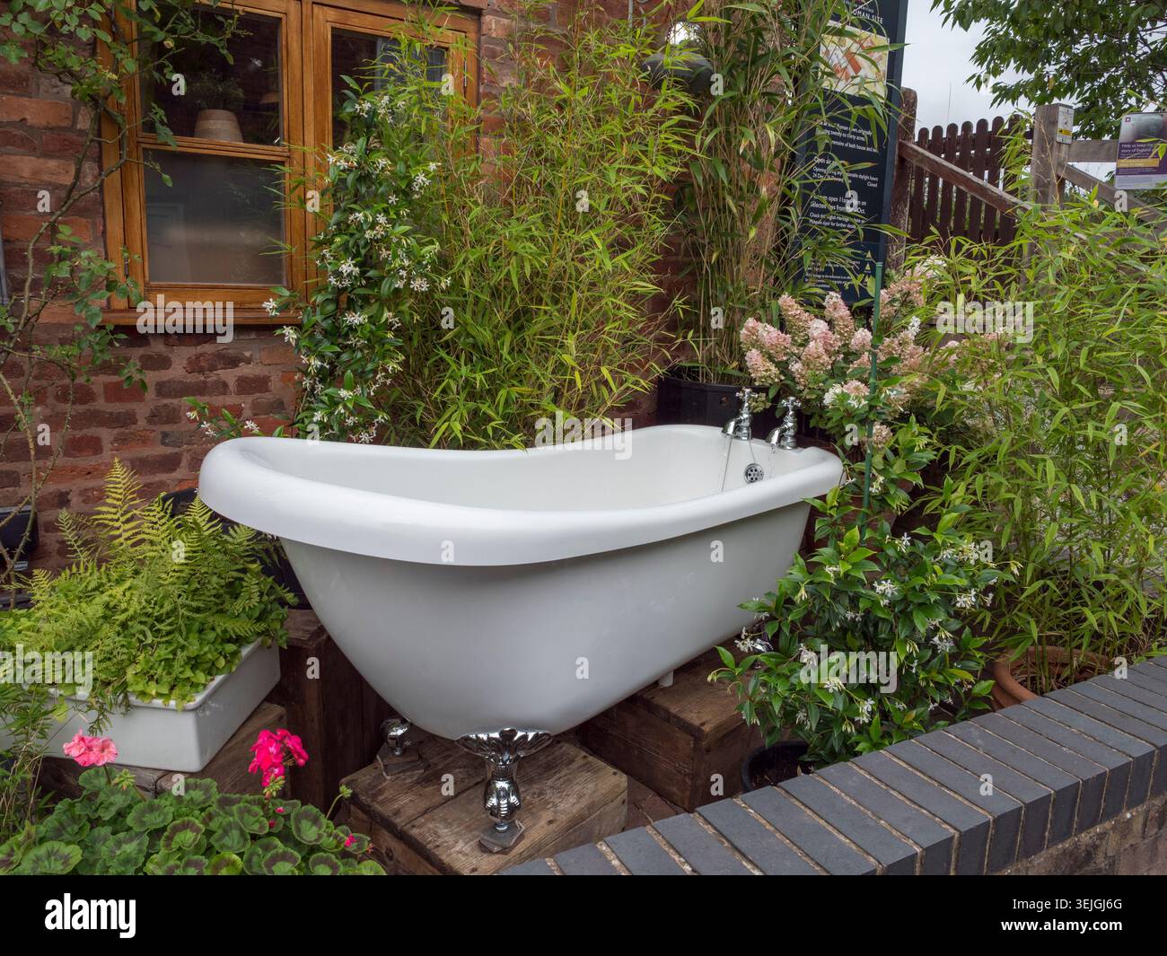 Una vasca da bagno come fontana da giardino nel giardino anteriore di una proprietà a Wall (WS14), Staffordshire, Regno Unito. Foto Stock