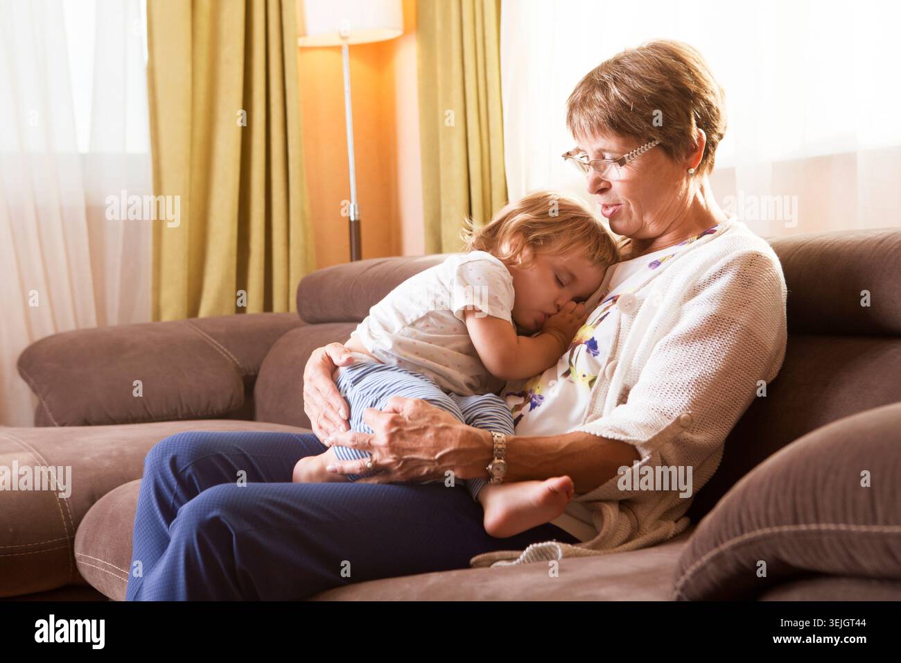 Il bambino dorme nelle mani di sua nonna Foto Stock