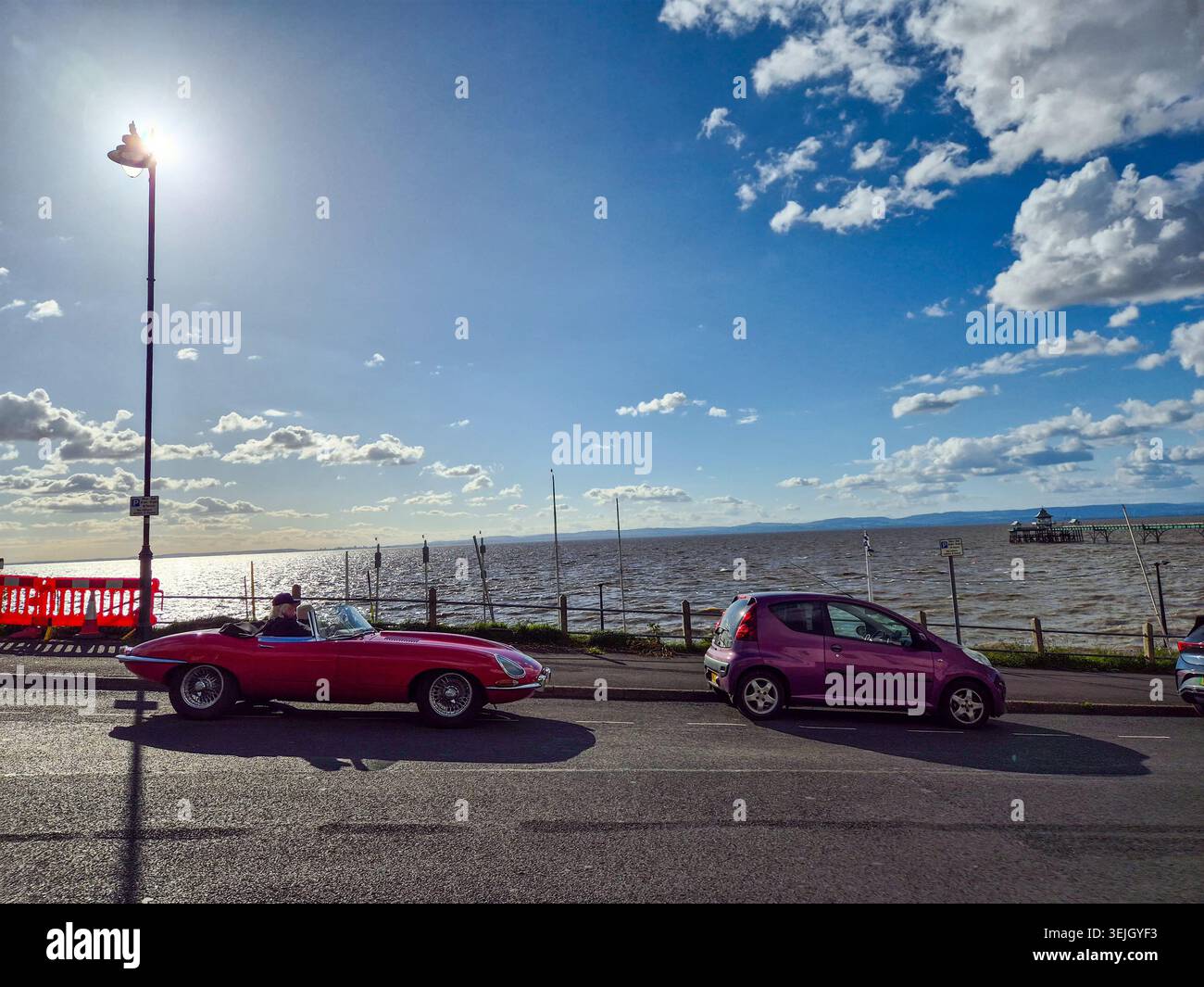 Roadster Jaguar E-Type rosso classico parcheggiato sulla strada del lungomare a Clevedon, Inghilterra Foto Stock