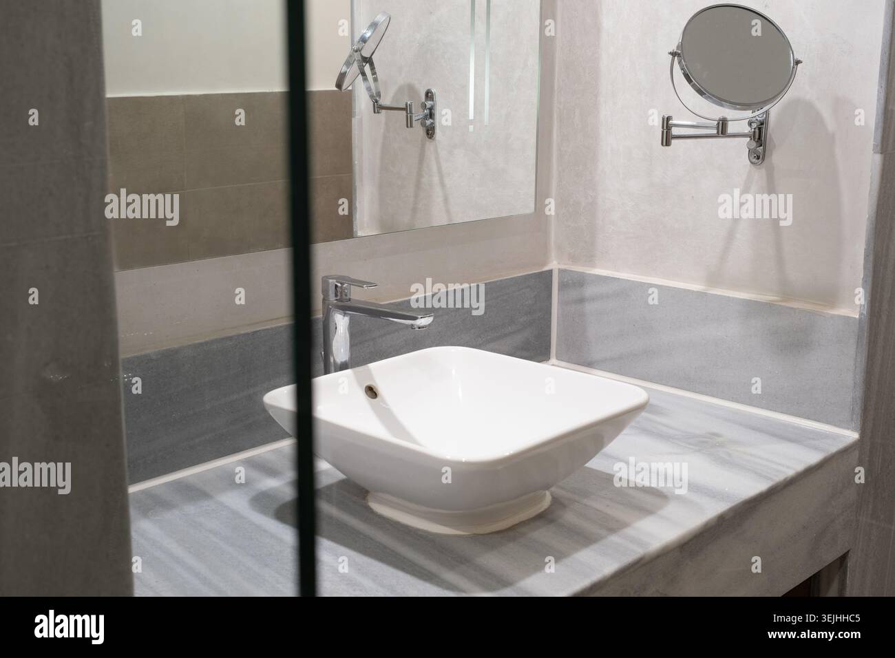 Rubinetto per acqua e lavello bianco sul banco in marmo Foto Stock