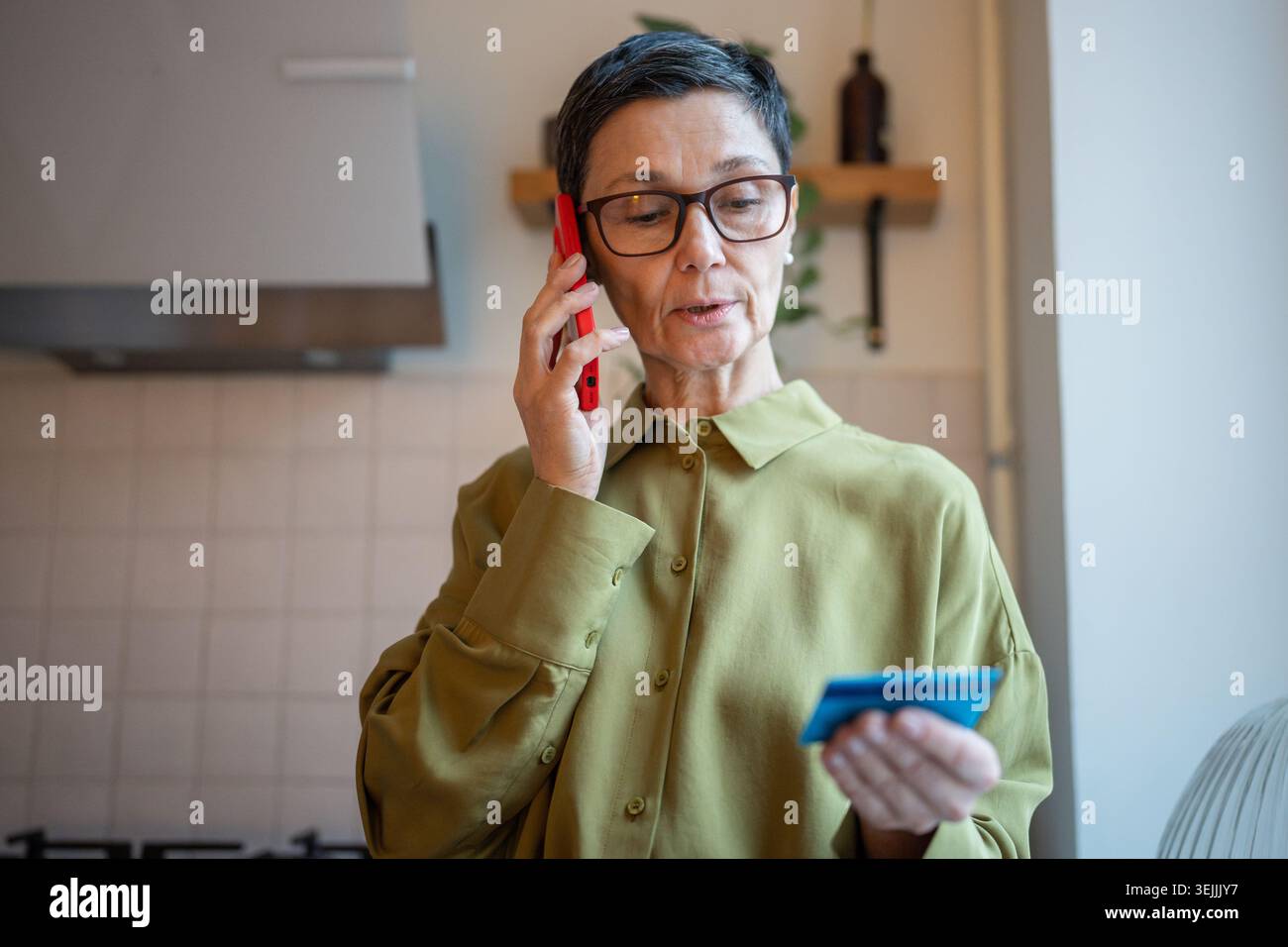 Donna anziana preoccupata che parla su smartphone con truffatori finanziari, che condivide i dati personali con i furti Foto Stock