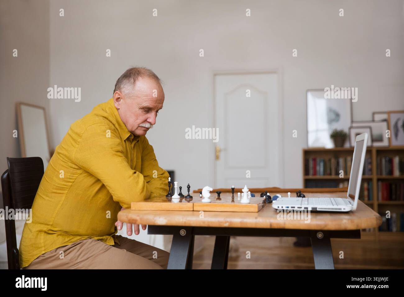 Vecchio anziano che gioca a scacchi sulla scacchiera, gioco online con un amico, videochiamata a causa del distanziamento sociale a casa Foto Stock