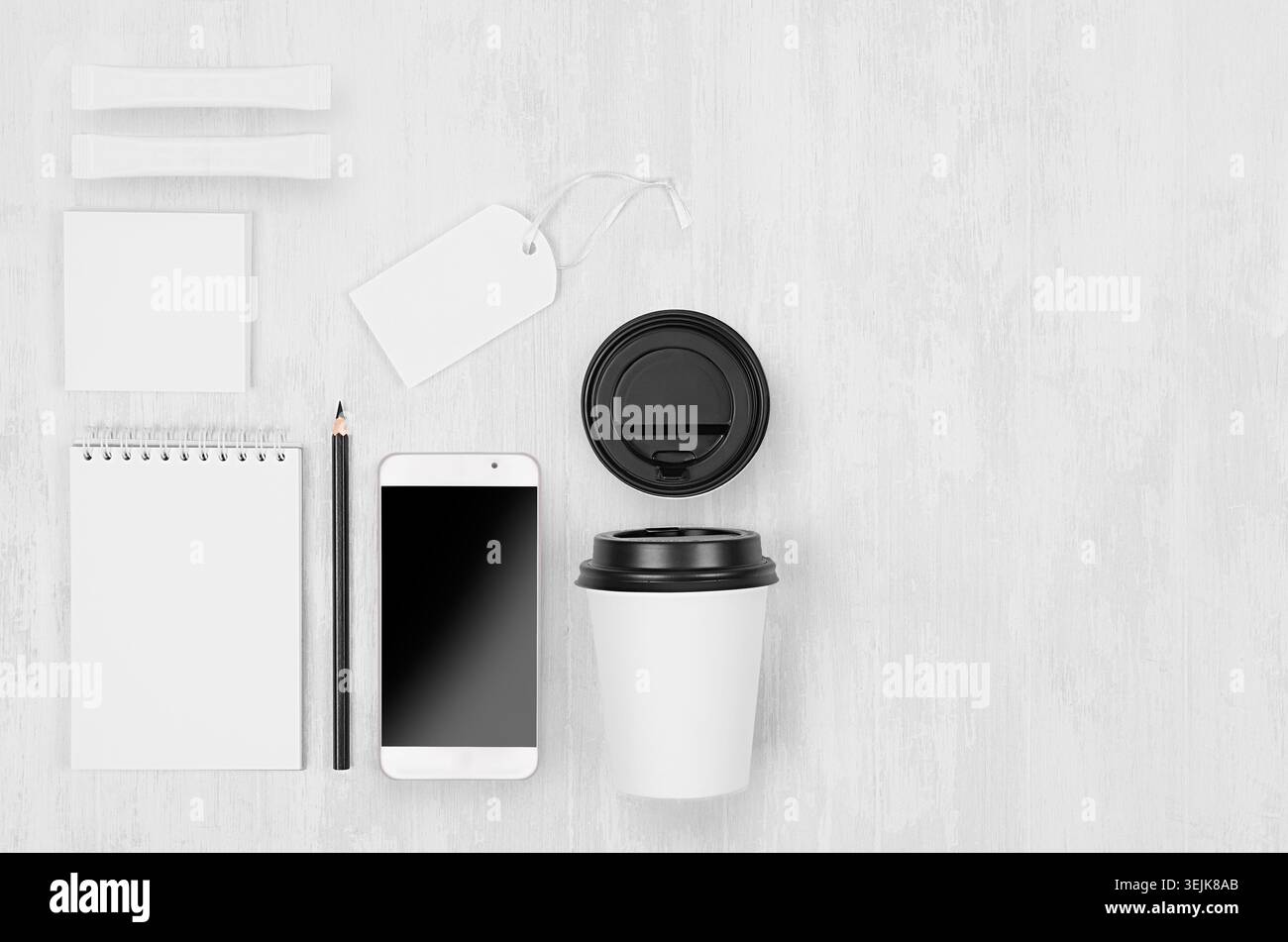 Modello di caffè ecologico per design, pubblicità e branding - tazza di carta bianca, telefono vuoto, notebook, etichetta, scheda su bianco Foto Stock