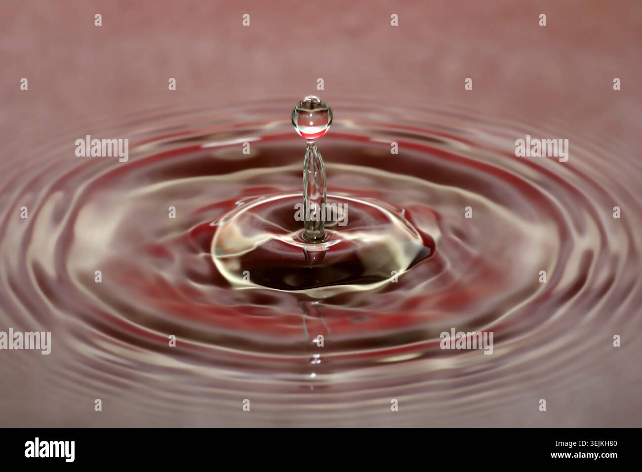 Fotografia a goccia, gocce d'acqua che cadono sulla superficie dell'acqua, colonna d'acqua, gioco di colori, foto in studio Foto Stock