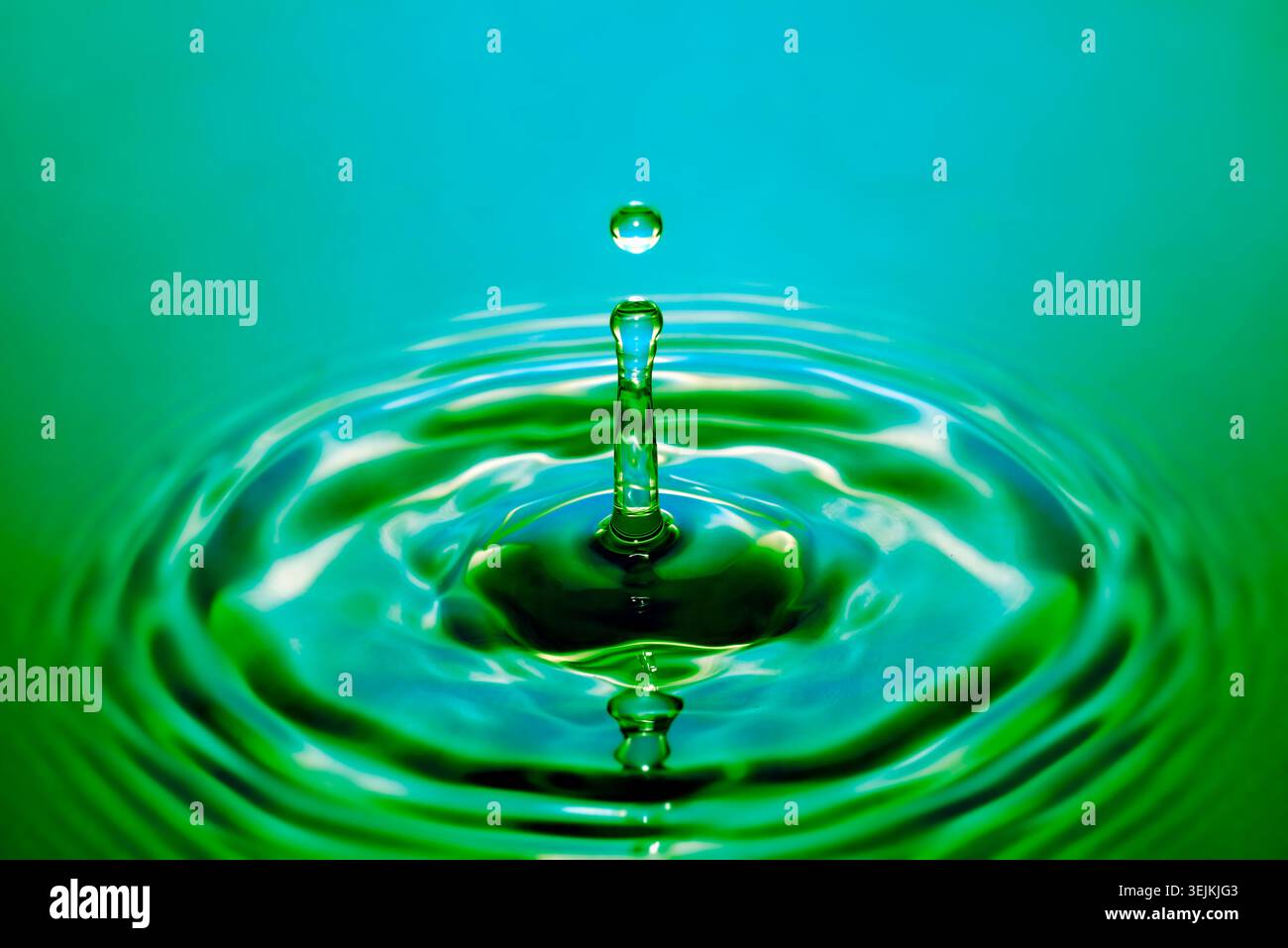 Fotografia a goccia, gocce d'acqua che cadono sulla superficie dell'acqua, colonna d'acqua, gioco di colori, foto in studio Foto Stock