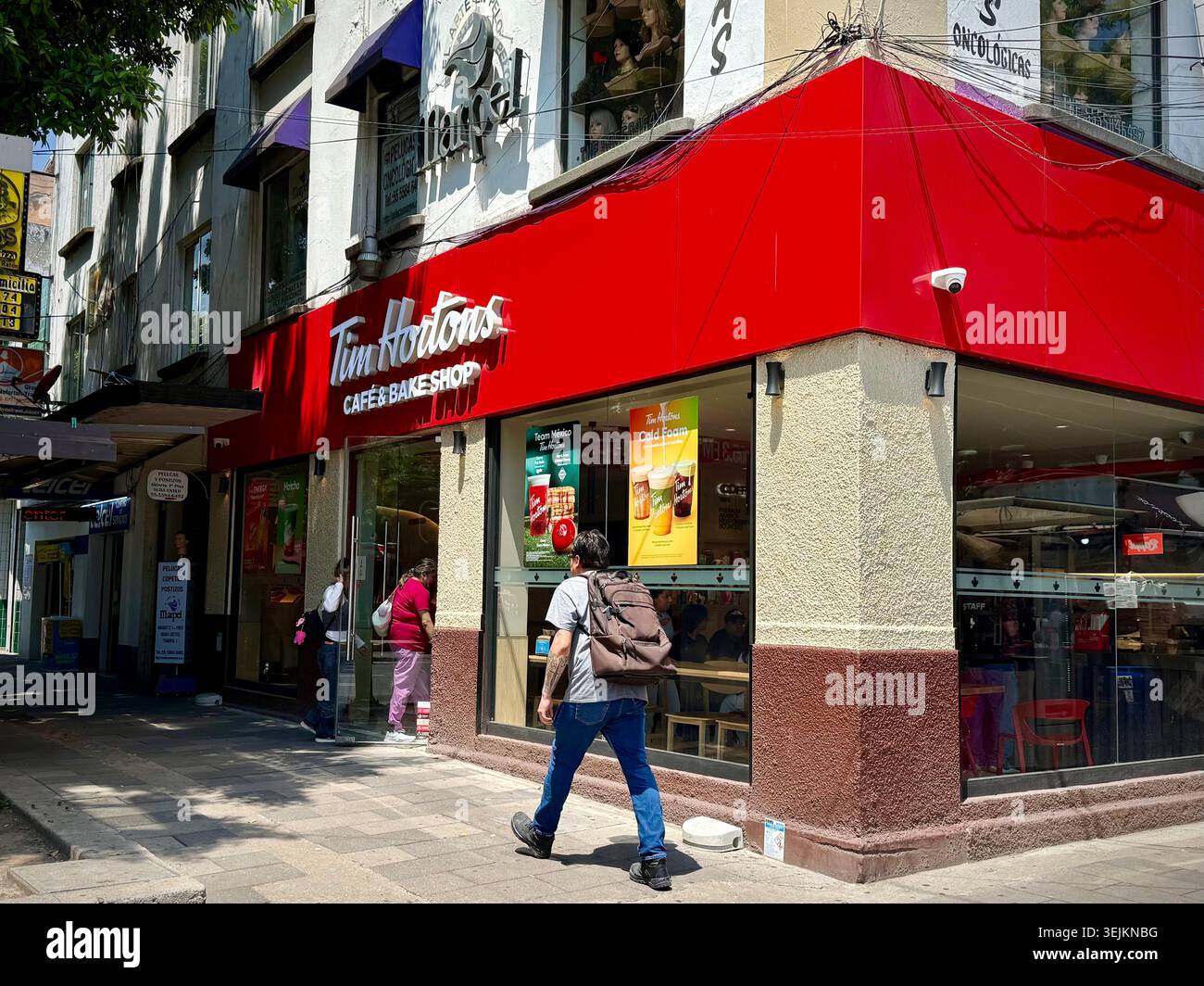 Una caffetteria Tim Hortons e una filiale di pasticceria a Condesa, città del Messico, che mostra l'espansione della catena di caffè canadese in Messico e la globalizzazione del commercio urbano - Immagine stock catturata con smartphone