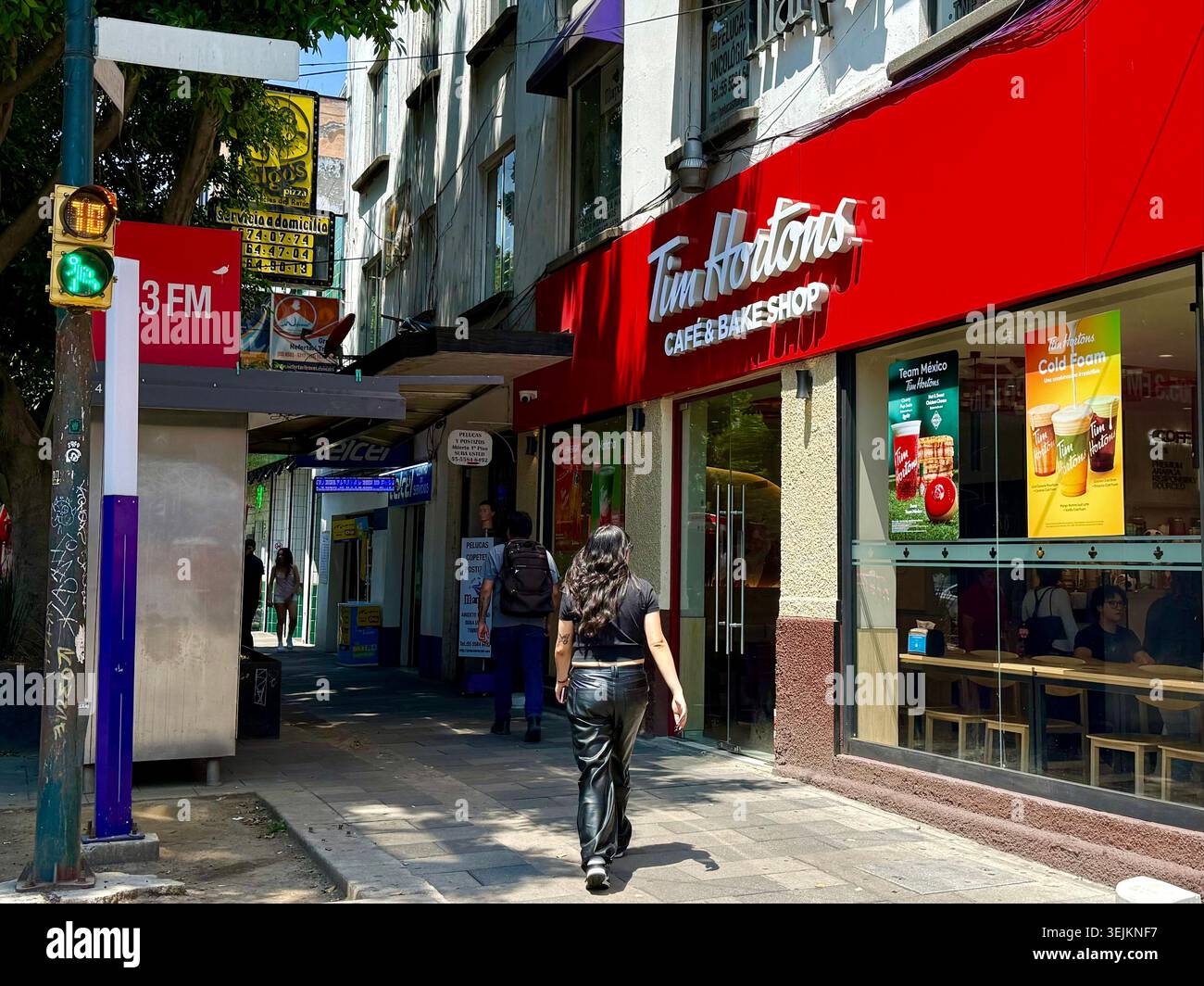 Una caffetteria Tim Hortons e una filiale di pasticceria a Condesa, città del Messico, che mostra l'espansione della catena di caffè canadese in Messico e la globalizzazione del commercio urbano - Immagine stock catturata con smartphone