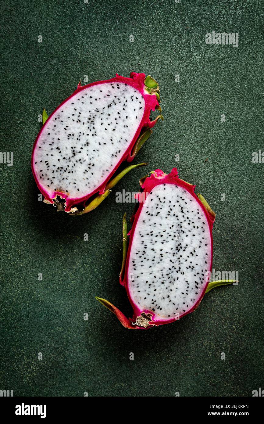 Dragon Fruit, pitahaya, un pezzo, taglio, vista dall'alto, stile rustico, sfondo verde, Foto Stock