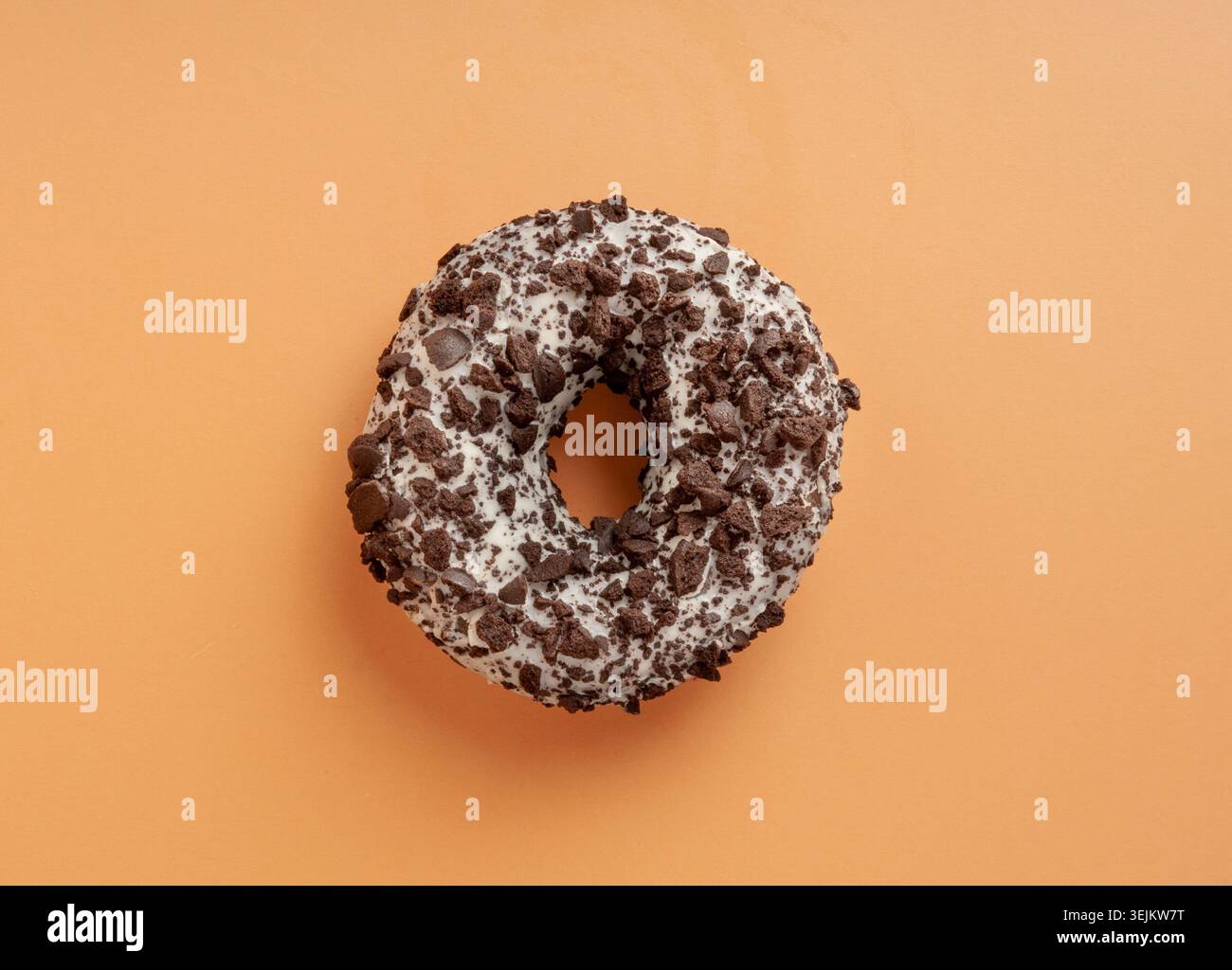 Nocciole al cioccolato isolate, ciambelle marroni con Sprinkles multicolore, Doughnuts su sfondo arancione Foto Stock