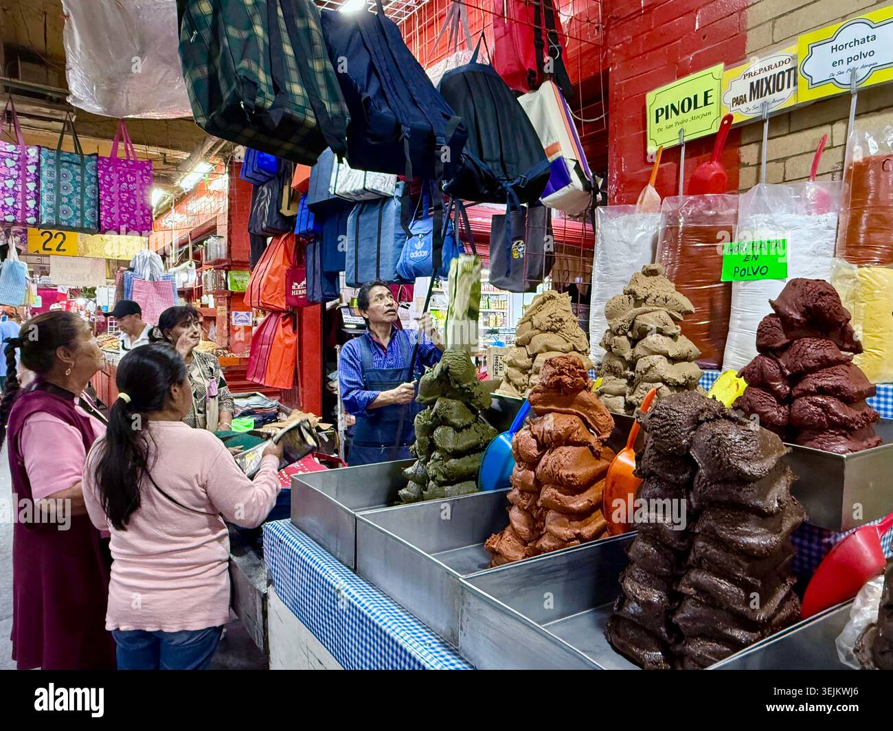 I clienti acquistano ingredienti tradizionali della cucina messicana, paste di talpa e prodotti secchi in una bancarella di Mercado de la Merced, città del Messico, Messico. - Immagine stock catturata con smartphone