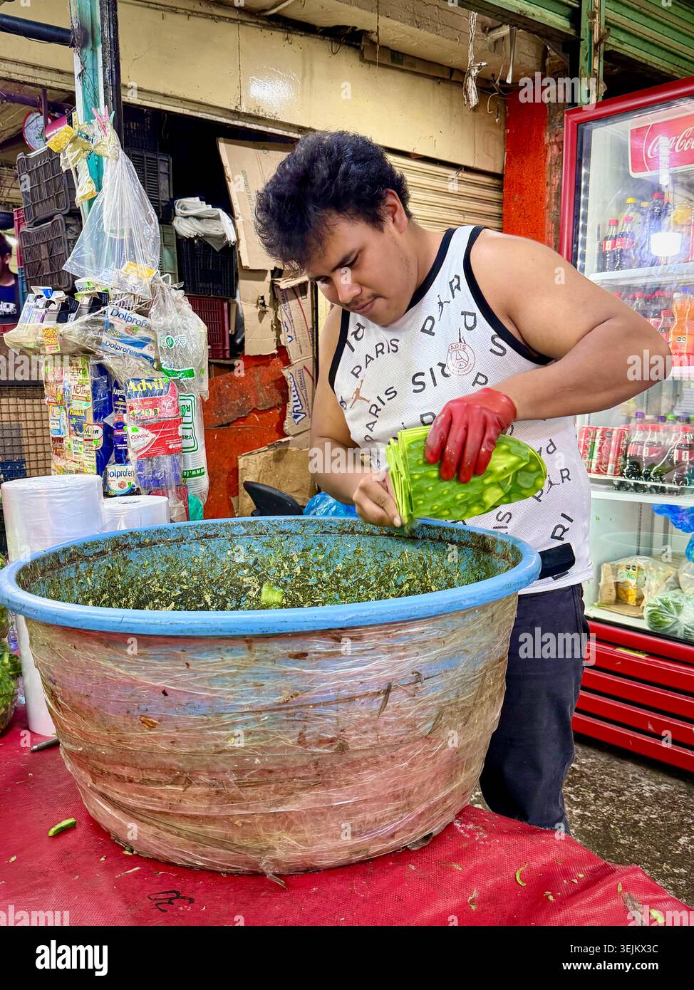 Un commerciante di mercato affetta pagaie di cactus, o nopales, al Mercado de la Merced di città del Messico, Messico. - Immagine stock catturata con smartphone