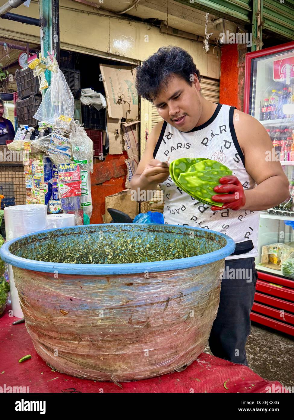 Un commerciante di mercato affetta pagaie di cactus, o nopales, al Mercado de la Merced di città del Messico, Messico. - Immagine stock catturata con smartphone