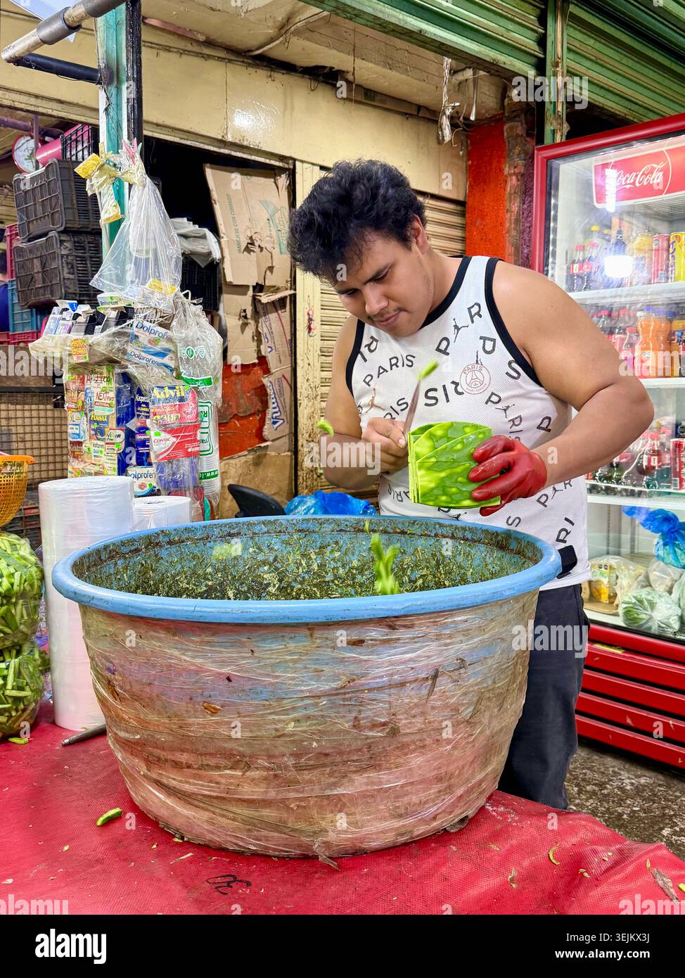 Un commerciante di mercato affetta pagaie di cactus, o nopales, al Mercado de la Merced di città del Messico, Messico. - Immagine stock catturata con smartphone