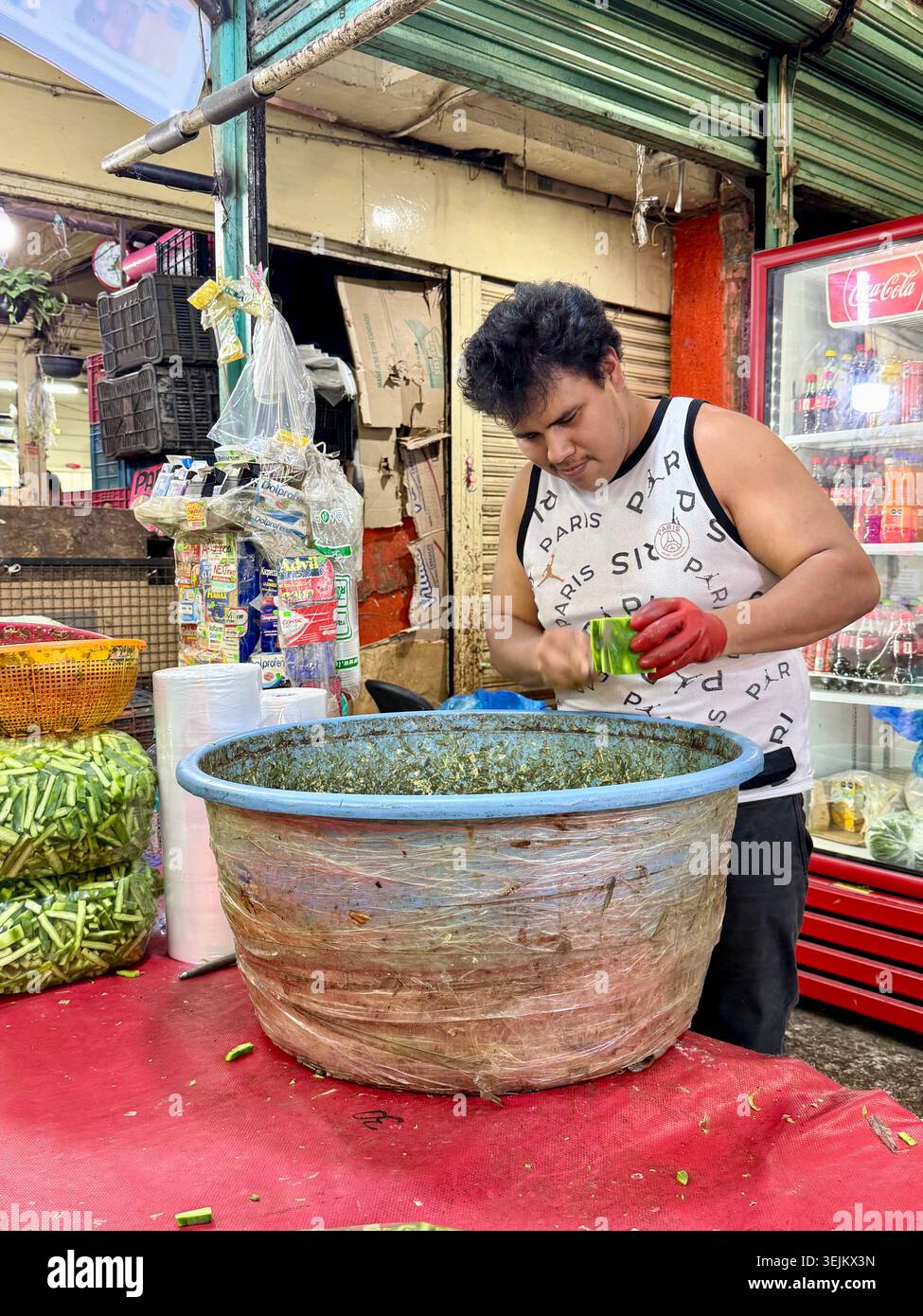 Un commerciante di mercato affetta pagaie di cactus, o nopales, al Mercado de la Merced di città del Messico, Messico. - Immagine stock catturata con smartphone