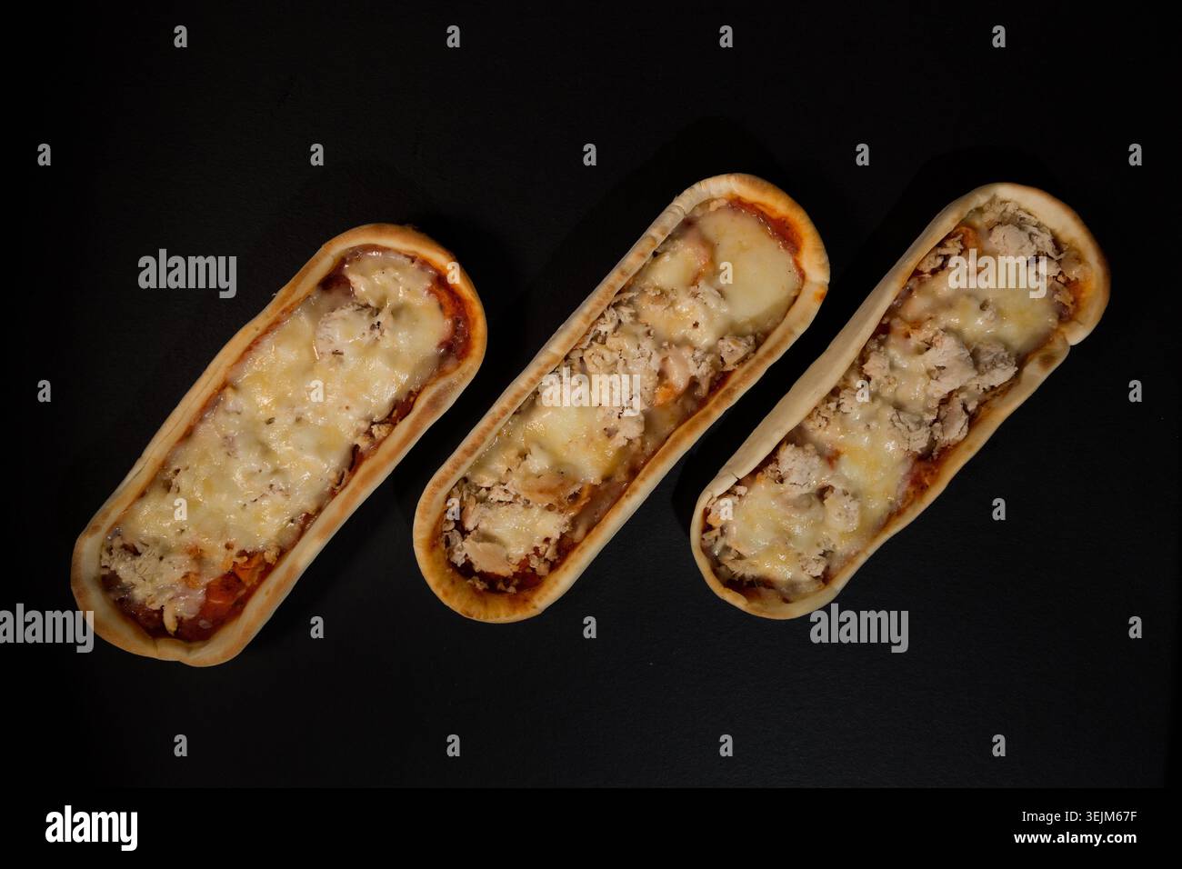 Mini pizze a forma di barca con pollo e formaggio fuso Foto Stock