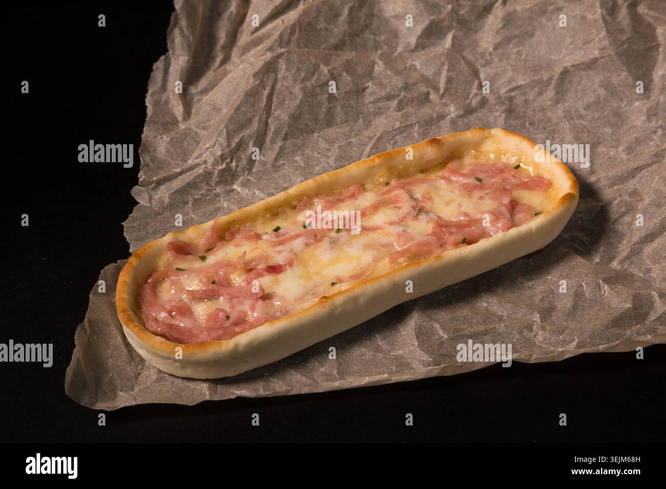 Mini pizze ovali con prosciutto grattugiato e formaggio fuso Foto Stock