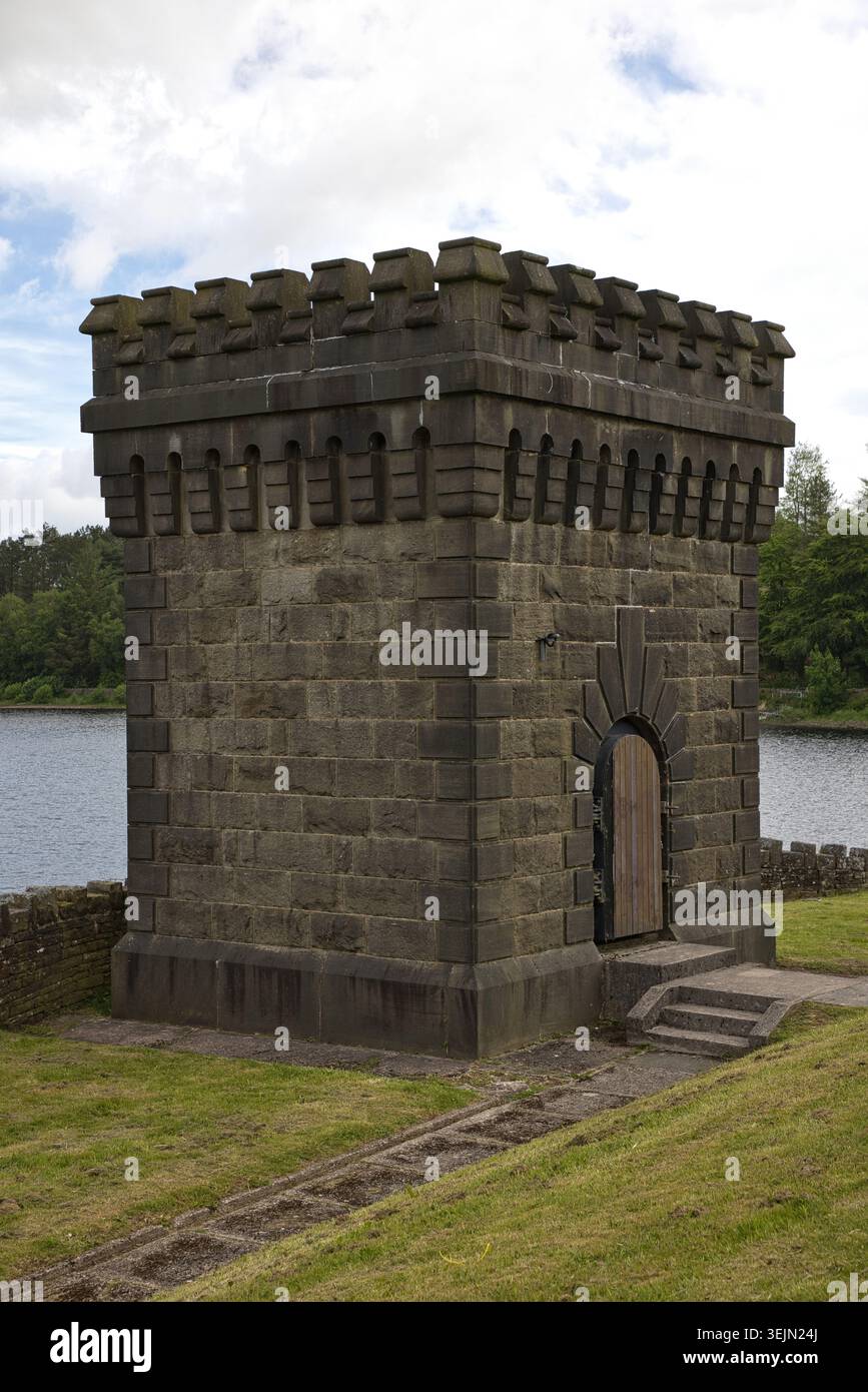 Una storica torre della valvola in pietra costruita in stile gotico su un argine erboso ai margini del bacino idrico di Entwistle, Lancashire, Regno Unito. Foto Stock