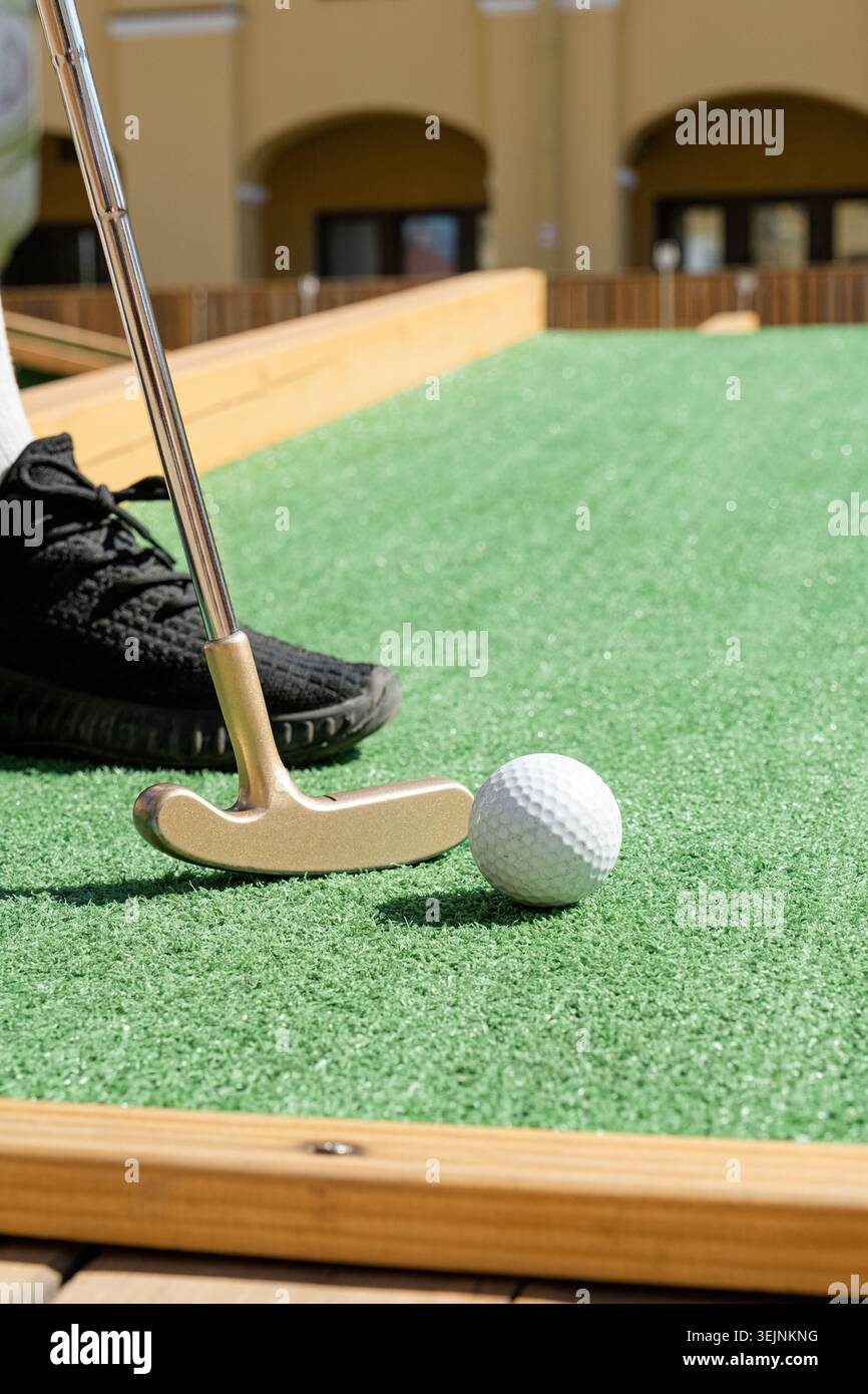 Persona irriconoscibile che gioca a minigolf Foto Stock