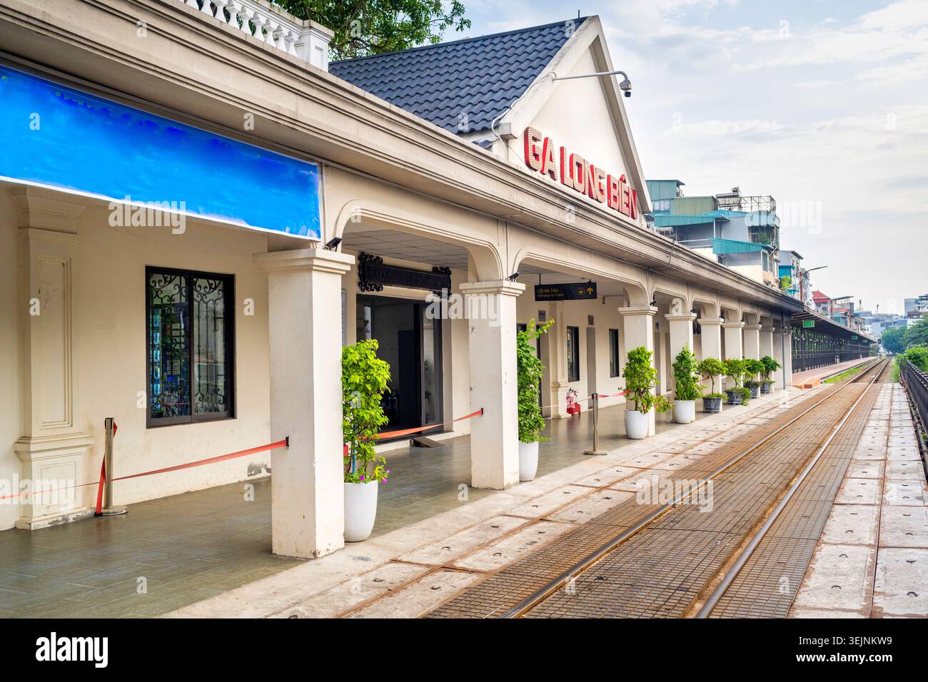 Stazione ferroviaria vicino al quartiere vecchio di Hanoi, situata vicino a un ponte storico in acciaio coloniale francese, che attraversa il vicino fiume Rosso Foto Stock