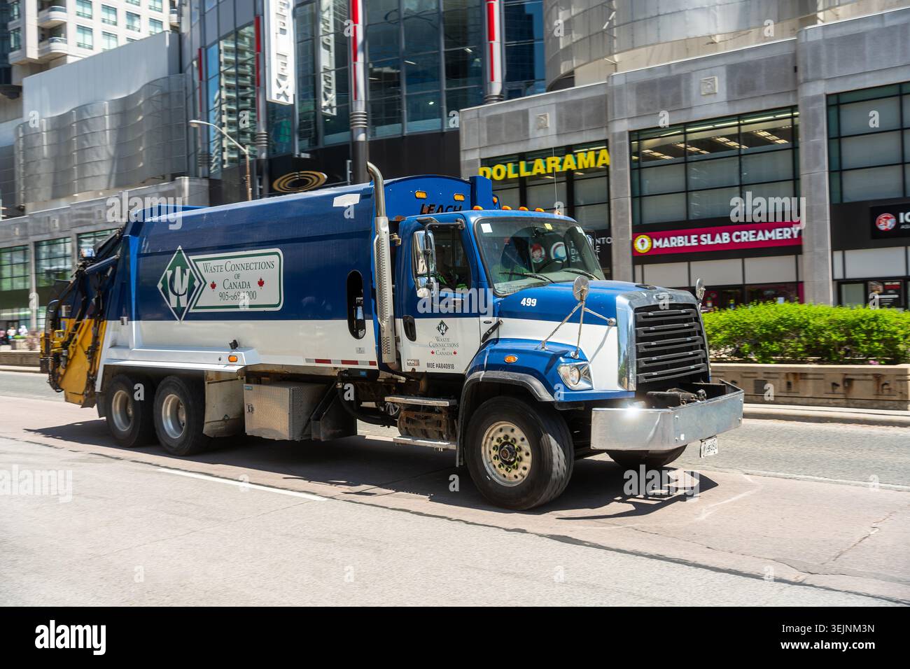 Toronto Canada - maggio 26 2026 collegamenti rifiuti camion della spazzatura che passa per i negozi al dettaglio del centro città Foto Stock