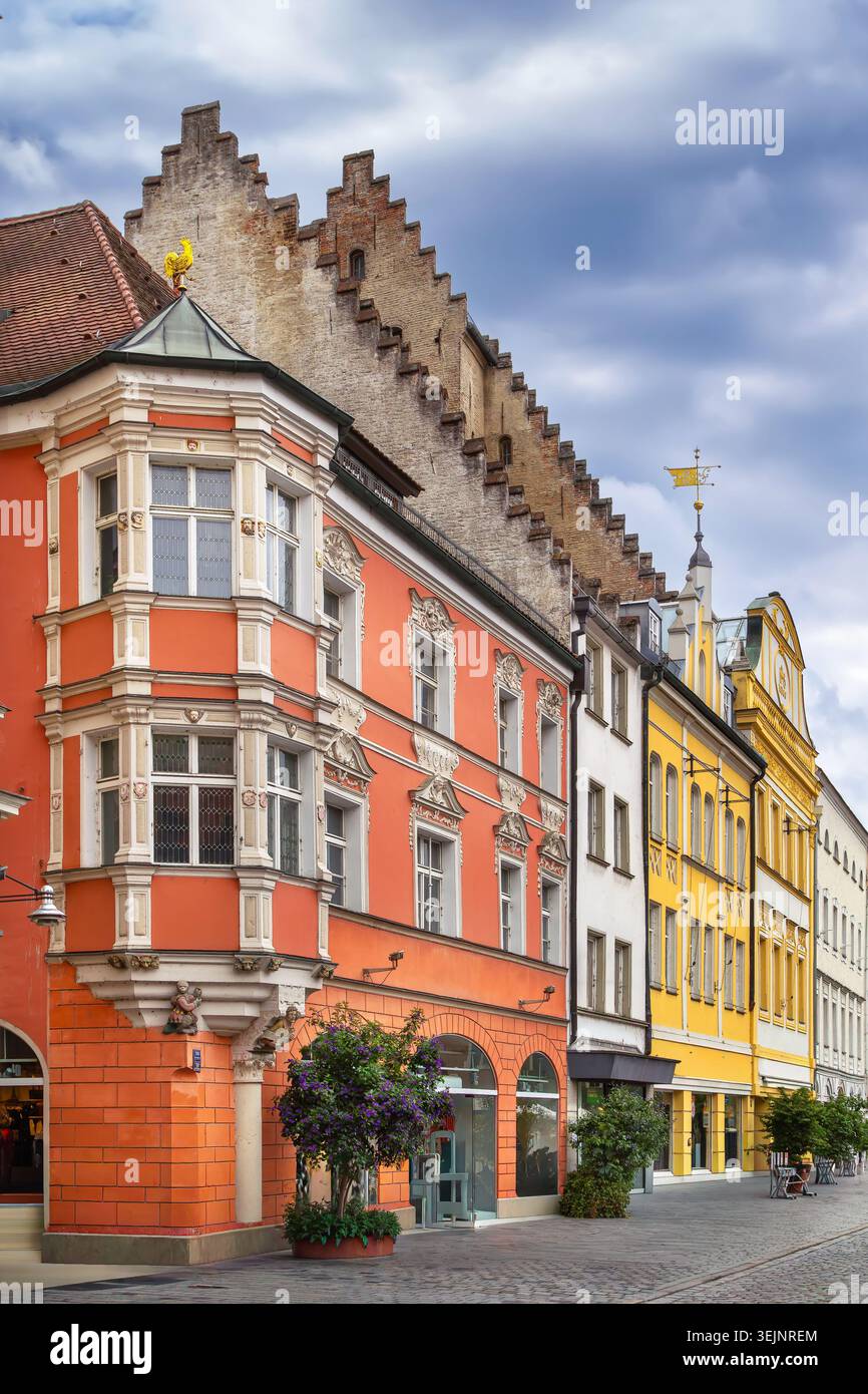 Edificio storico rosso con finestra ad angolo a Straubing, Germania. Case della città vecchia in una strada pedonale sotto il cielo nuvoloso Foto Stock