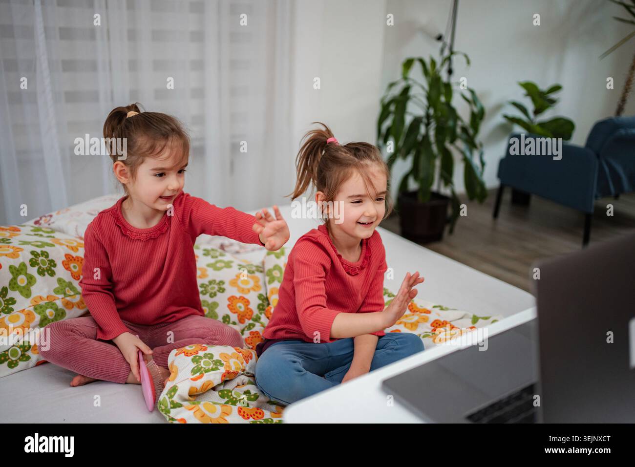 Ragazze che si divertono a videochiamare con un notebook a casa Foto Stock