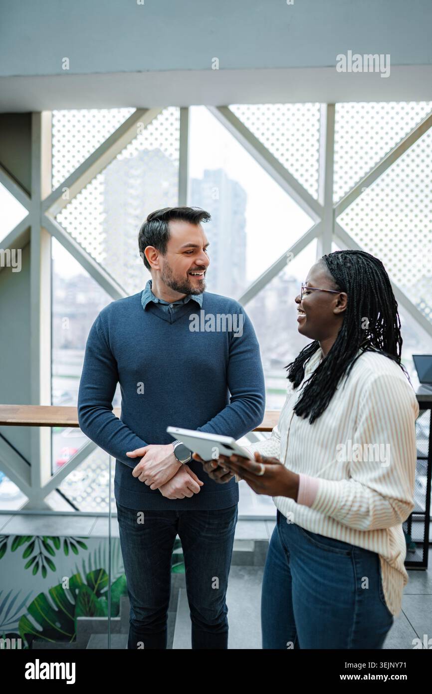 Colleghi che collaborano e discutono idee aziendali con un tablet digitale Foto Stock