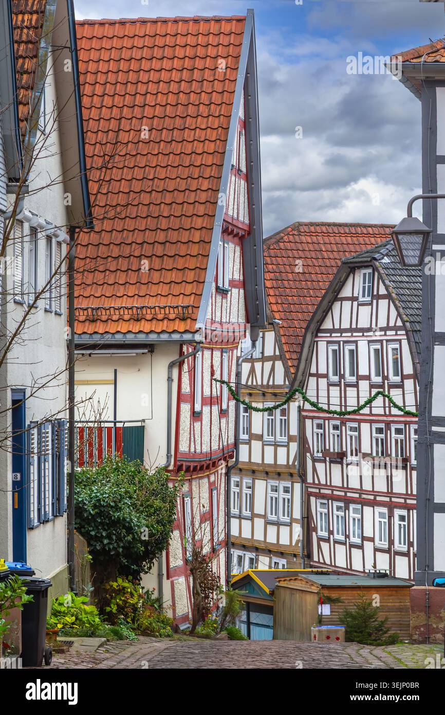 Strada stretta con case in legno a Schlitz in Germania. Architettura tradizionale sotto il cielo nuvoloso alla luce del giorno Foto Stock