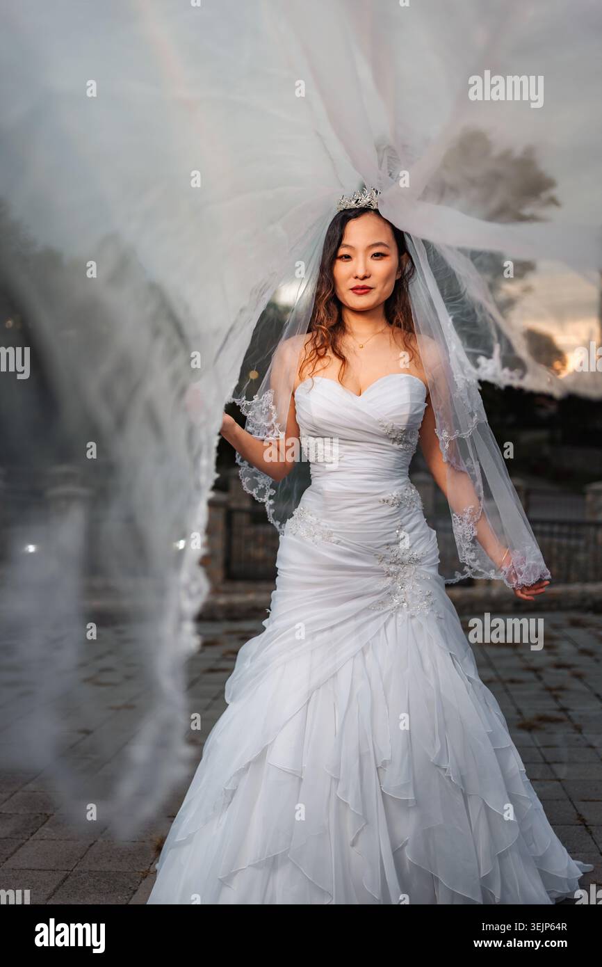 Sposa cinese che indossa abiti da sposa e velo per le nozze Foto Stock