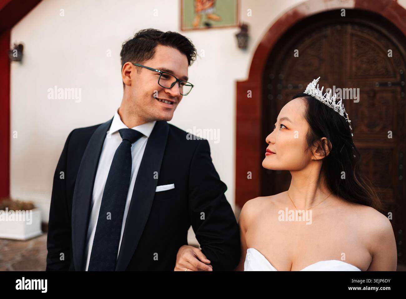 Coppia di nozze interrazziale che si guardano sorridendo Foto Stock