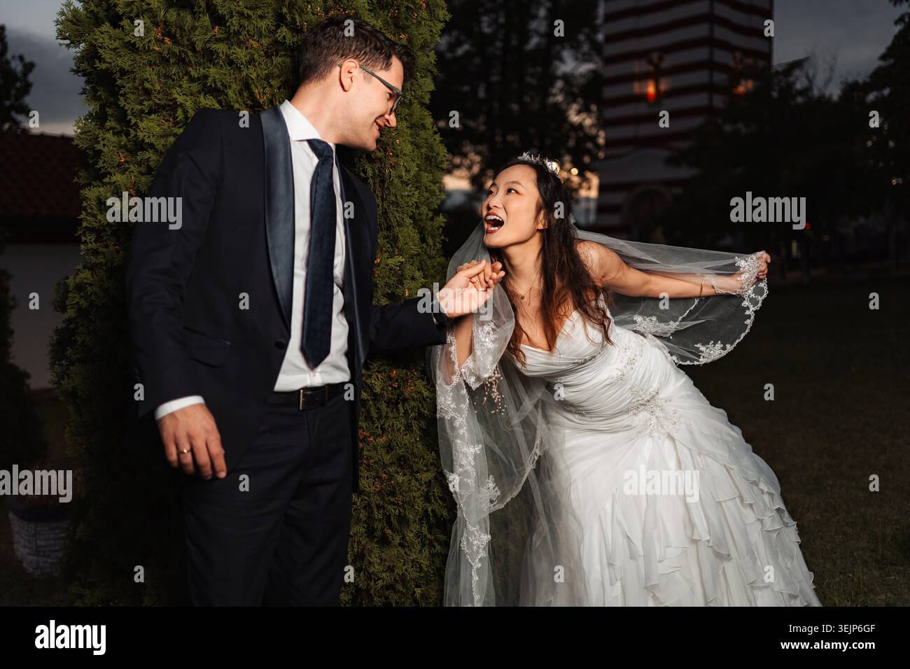 Coppia interrazziale che festeggia il giorno del matrimonio con gioia Foto Stock