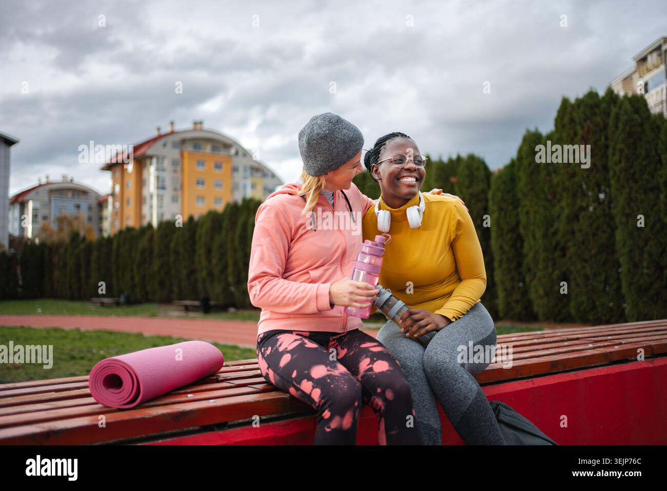Diverse donne e amici riposano dopo l'allenamento all'aperto Foto Stock