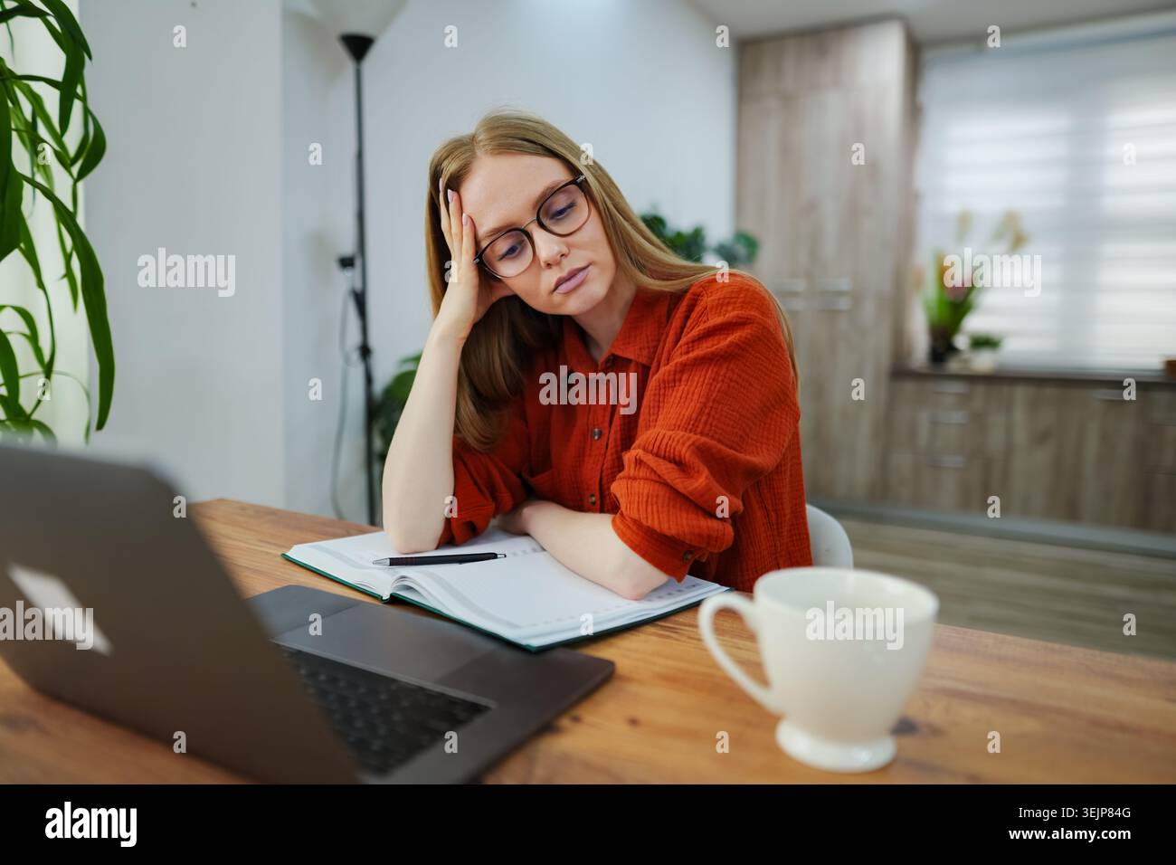Gli studenti concentrati esaminano i materiali di studio nell'accogliente spazio di lavoro domestico Foto Stock