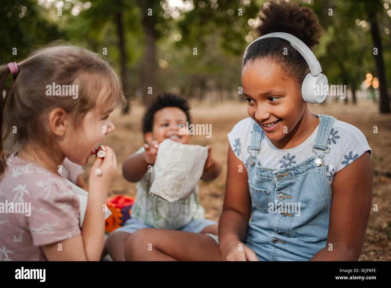 I bambini mangiano popcorn e si divertono nel parco Foto Stock