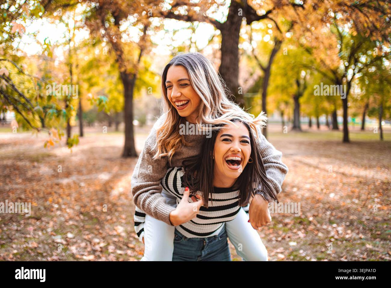 Momenti autunnali felici condivisi tra due amici nel parco Foto Stock