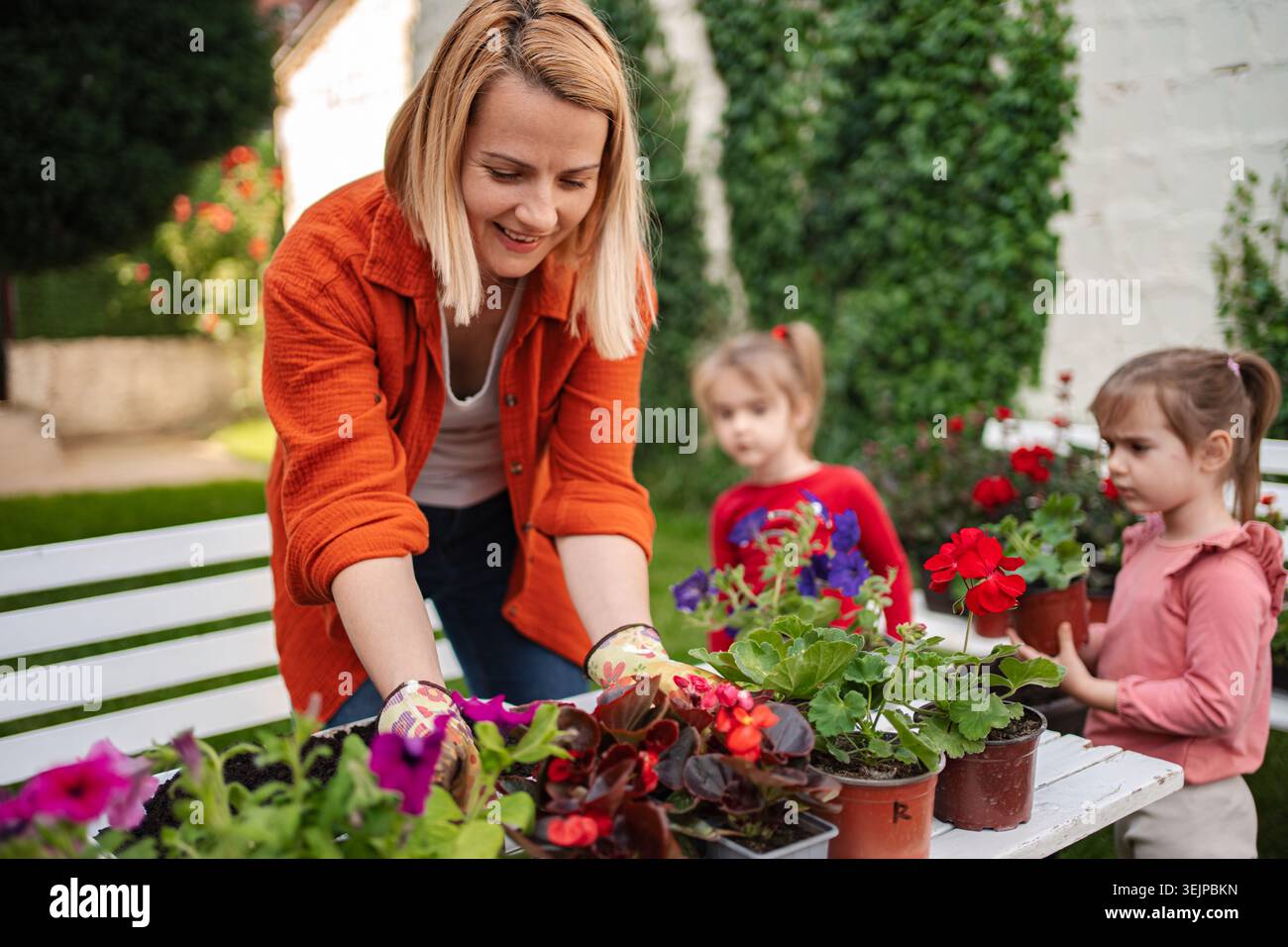 Giardinaggio con i bambini in un cortile soleggiato Foto Stock
