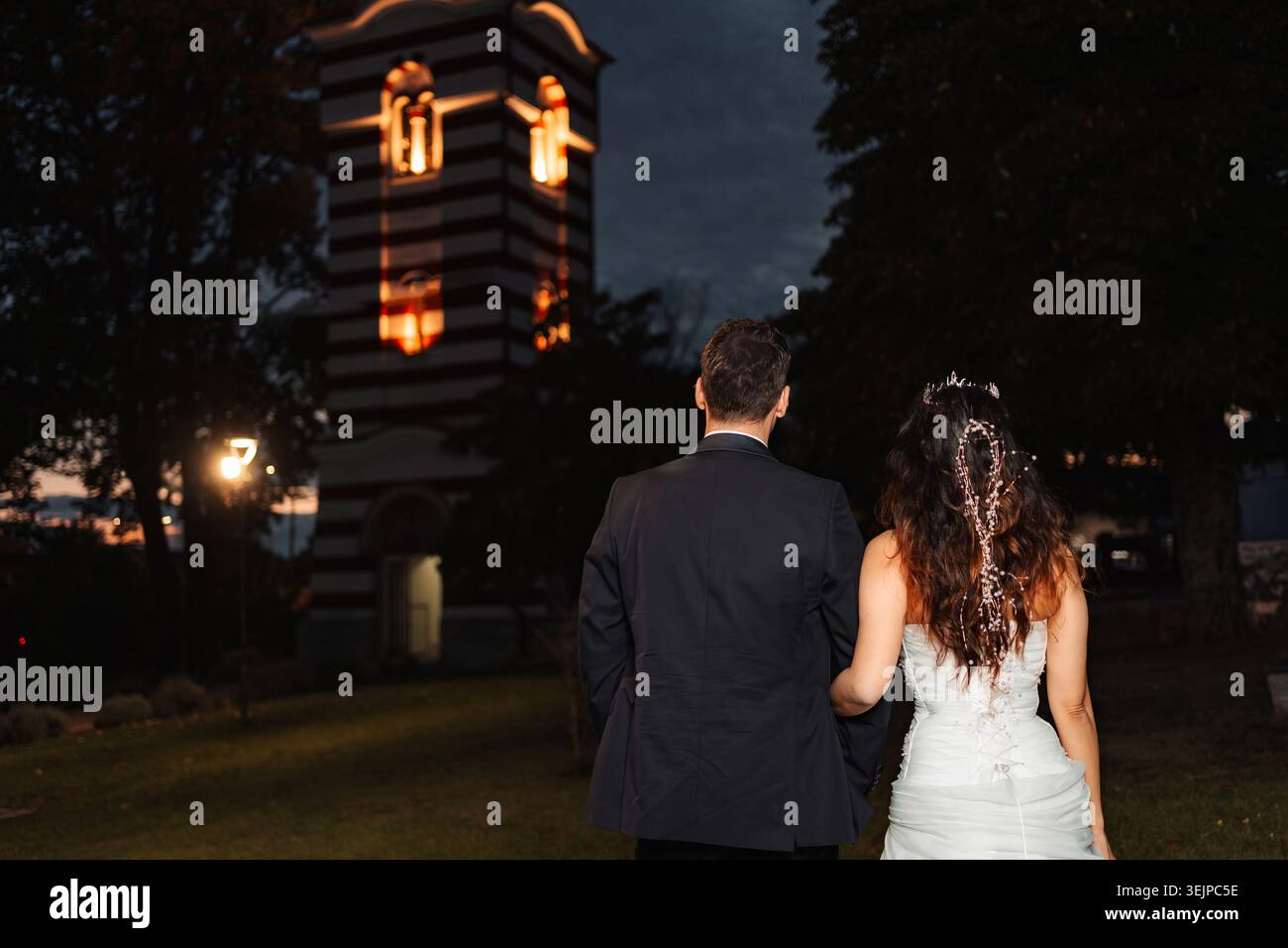 La coppia di nozze cammina verso la chiesa di notte Foto Stock