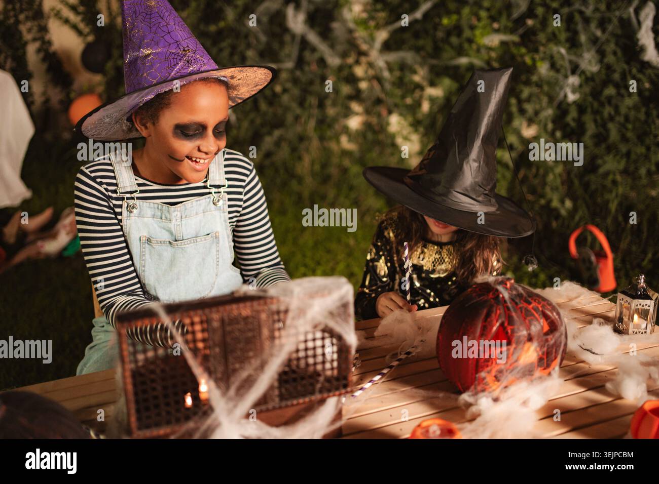 Due ragazze che fanno decorazioni di Halloween a casa Foto Stock