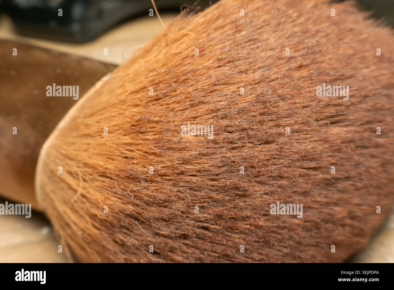 Vista macro delle setole morbide del pennello per il trucco che mostrano una trama dettagliata della fibra toni marroni caldi e superficie dello strumento di bellezza cosmetica per creare lo sfondo e disegnare Foto Stock