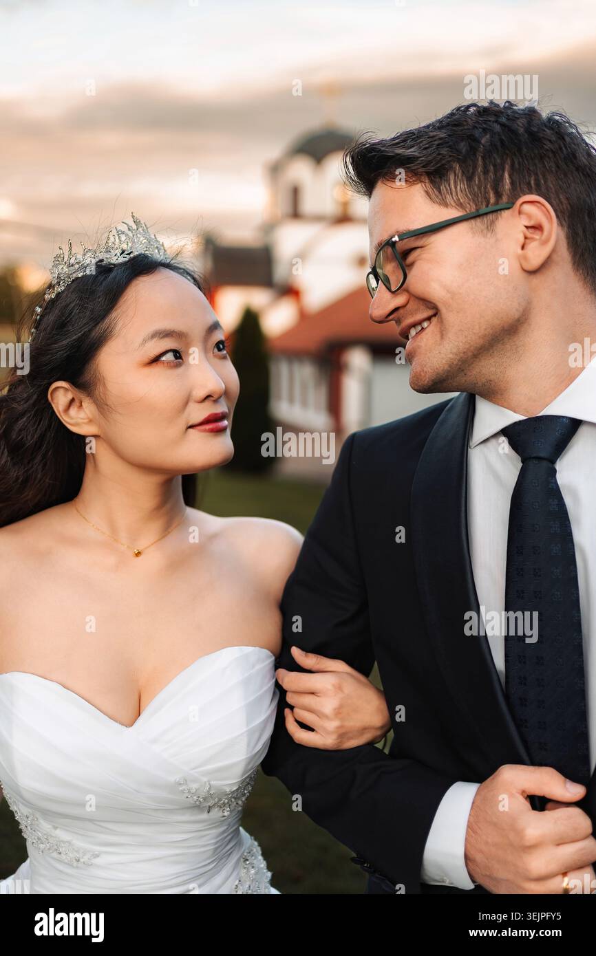 Coppia interrazziale che celebra il giorno del matrimonio guardarsi l'un l'altro Foto Stock