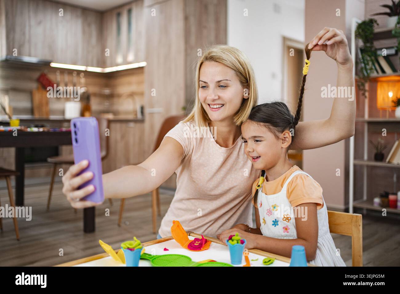 Madre e figlia si godono un momento di gioco mentre fanno un selfie Foto Stock